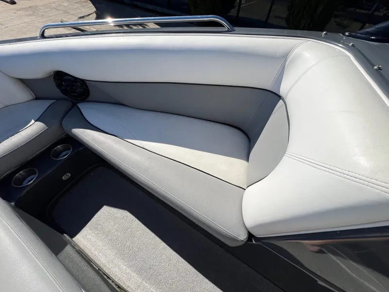 Slide: The Image of 2007 Supra 24SSV boat interior with gray and white seating, cup holders, and speaker. - 17