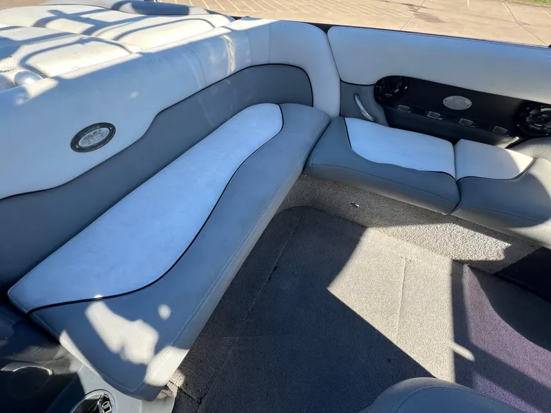 Slide: The Image of 2007 Supra 24SSV boat interior with gray and white seating, carpeted floor, and speaker system. - 8