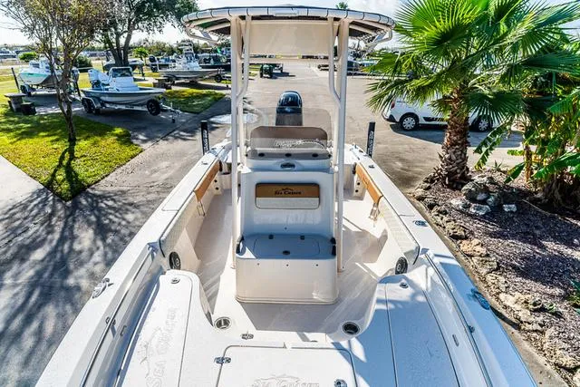 Slide: The Image of 2025 Carolina Skiff 23LX boat, spacious deck, parked near palm trees. - 11