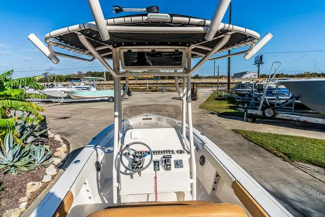 Slide: The Image of 2025 Carolina Skiff 23LX boat with center console and T-top in a marina setting. - 19