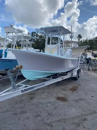 Slide: The Image of 2025 Exuma 22 CC boat on trailer under cloudy sky. - 2