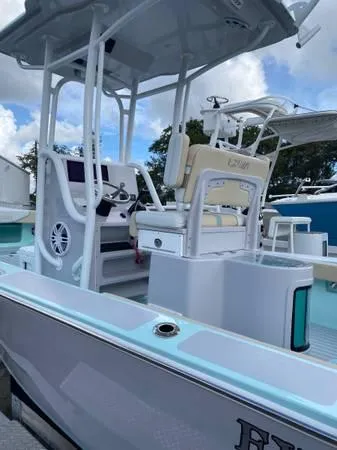 Slide: The Image of 2025 Exuma 22 CC boat with sleek design and modern features, docked under a blue sky. - 4