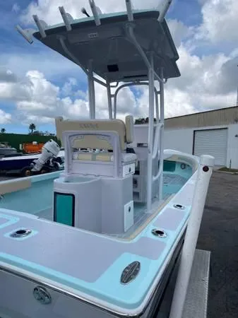 Slide: The Image of 2025 Exuma 22 CC boat with T-top, docked under cloudy sky. - 6