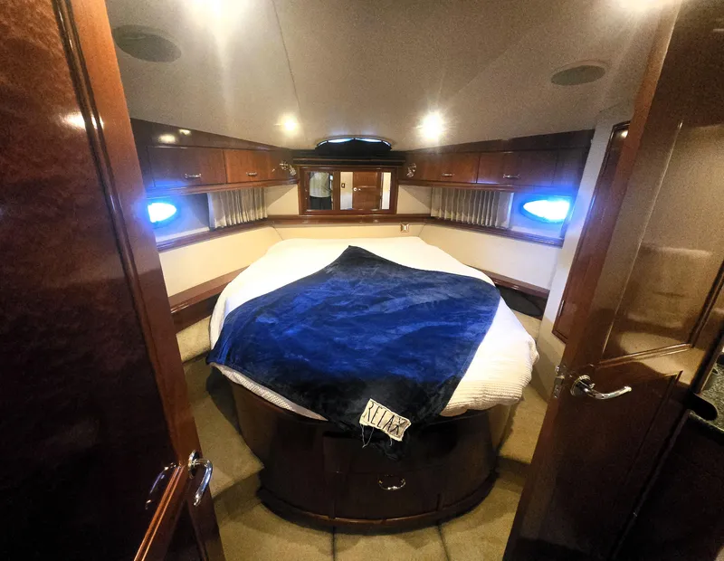 Slide: The Image of Luxurious 2004 Carver 460 Voyager yacht bedroom with cozy bed and elegant wood finishes. - 16