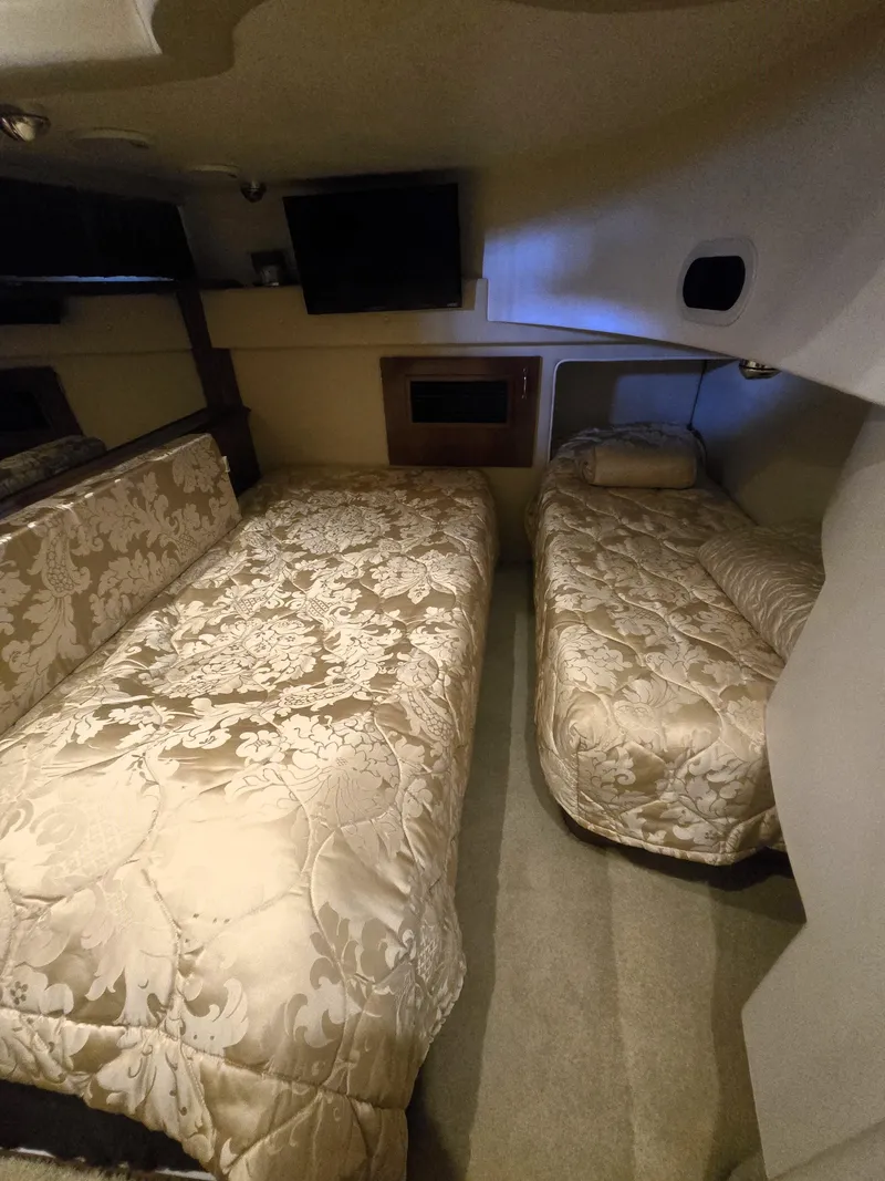 Slide: The Image of 2004 Carver 460 Voyager cabin with twin beds and elegant bedding. - 17