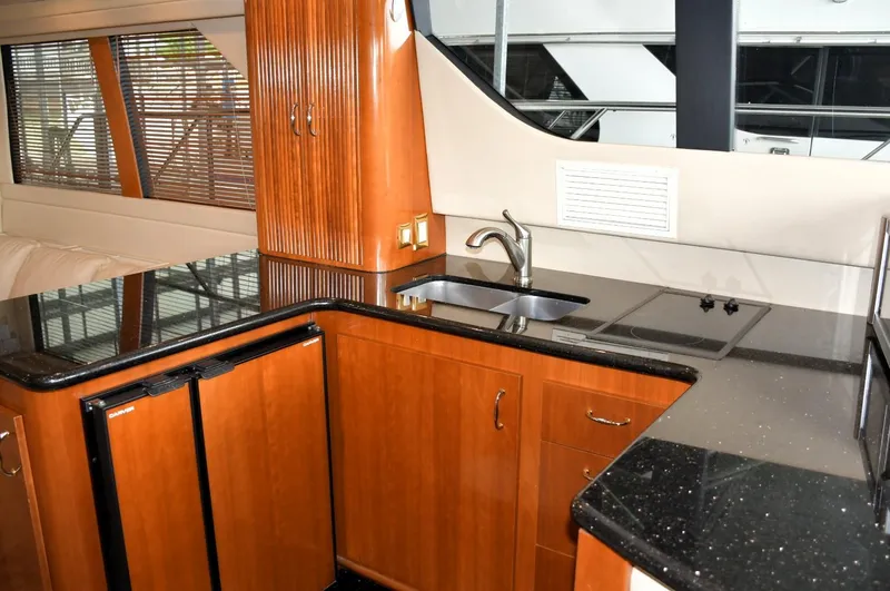 Slide: The Image of 2004 Carver 460 Voyager yacht kitchen with wood cabinets and black countertops. - 7