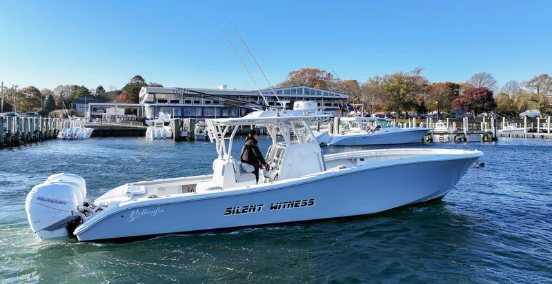 Slide: The Image of 2021 Yellowfin 36 Offshore boat on water near marina, clear sky background. - 2