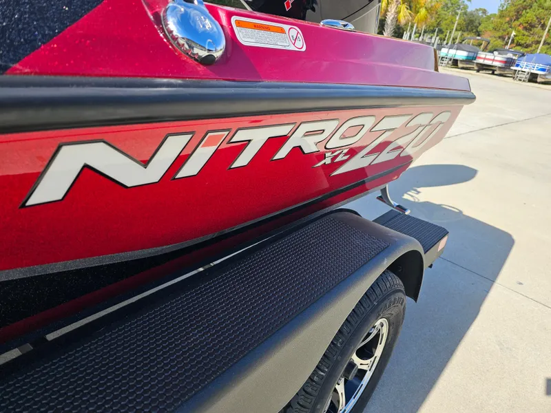 Slide: The Image of 2025 Nitro Z20 XL Pro boat, red exterior, parked on trailer. - 26
