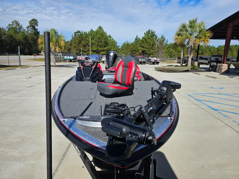 Slide: The Image of 2025 Nitro Z20 XL Pro bass boat with red seats in a parking lot. - 4
