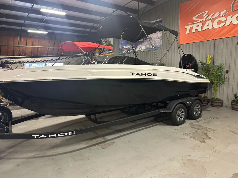 The Image of 2025 Tahoe T21 boat on trailer in showroom with Sun Tracker sign. - 0