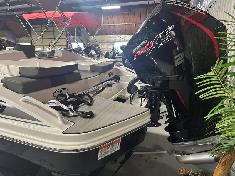 Slide: The Image of 2025 Tahoe T21 boat with Mercury Pro XS engine in showroom setting. - 2