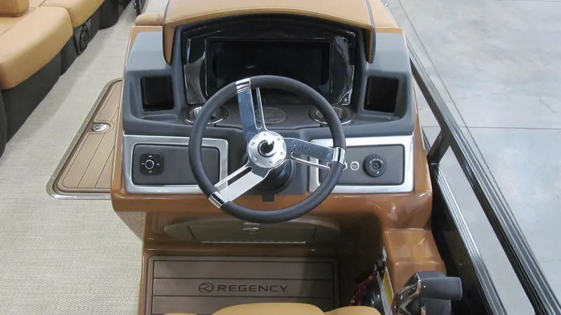 Slide: The Image of 2025 Regency 250 LE3 Sport boat dashboard with steering wheel and controls. - 10