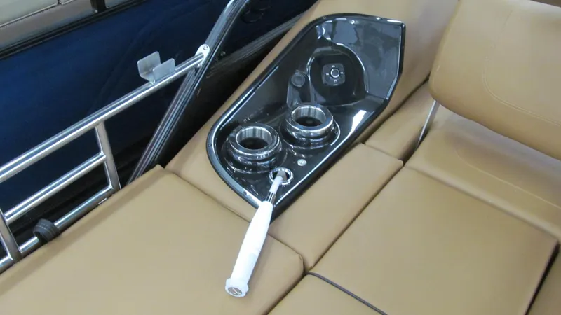Slide: The Image of Regency 250 LE3 Sport 2025 boat interior with cup holders and tan seating. - 16