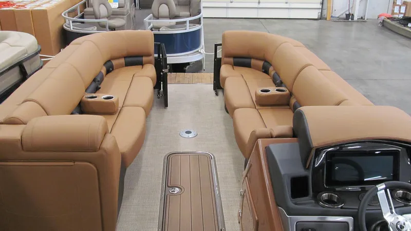 Slide: The Image of 2025 Regency 250 LE3 Sport pontoon boat interior with tan seating and modern dashboard. - 18