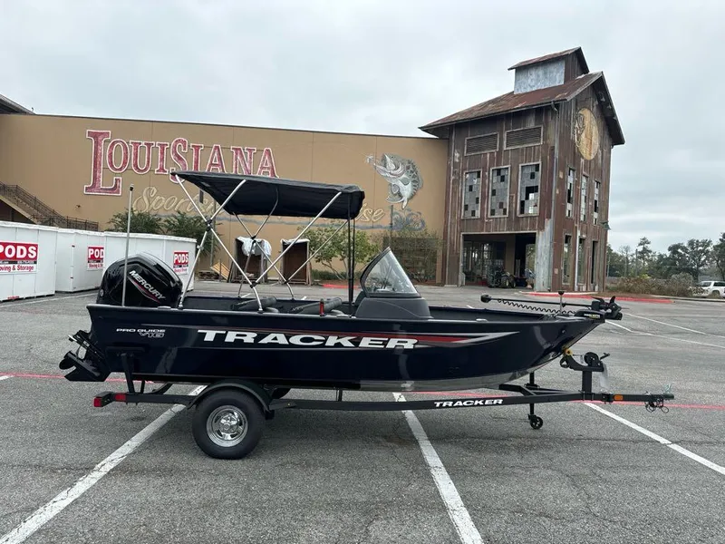 Slide: The Image of 2025 Tracker Pro Guide V-16 WT boat in parking lot, Louisiana backdrop. - 2