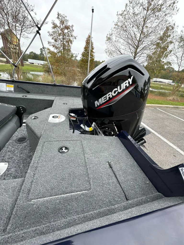 Slide: The Image of 2025 Tracker Pro Guide V-16 WT boat with Mercury engine in a parking lot. - 5