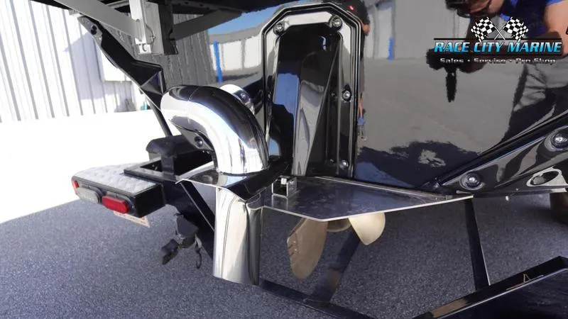 Slide: The Image of 2025 Nautique Super Air Nautique S23 boat rear view with propeller and exhaust system. - 10