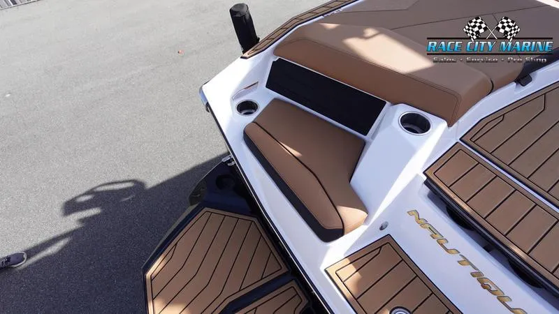 Slide: The Image of 2025 Nautique Super Air Nautique S23 boat deck with brown seating and Race City Marine logo. - 13