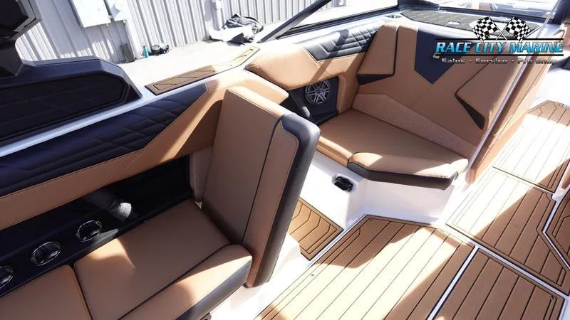 Slide: The Image of Luxurious interior of 2025 Nautique Super Air Nautique S23 boat with tan and black seating. - 25