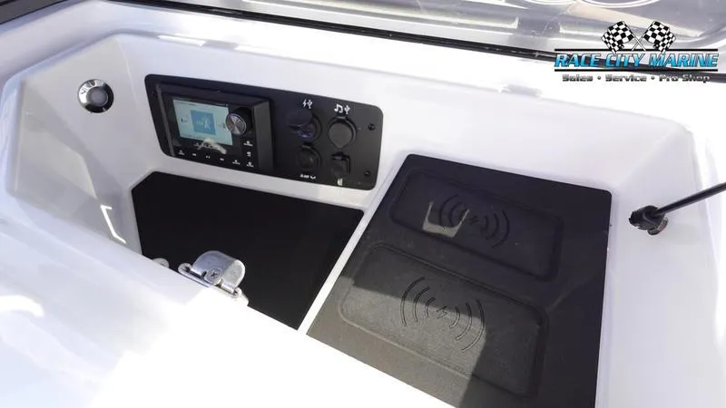 Slide: The Image of 2025 Nautique Super Air Nautique S23 dashboard with control panel and wireless charging pads. - 29