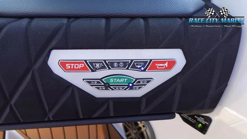 Slide: The Image of Control panel of 2025 Nautique Super Air Nautique S23 boat with start and stop buttons. - 33