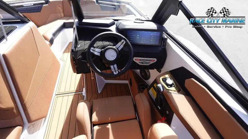 Slide: The Image of 2025 Nautique Super Air Nautique S23 boat interior with modern dashboard and tan seating. - 41