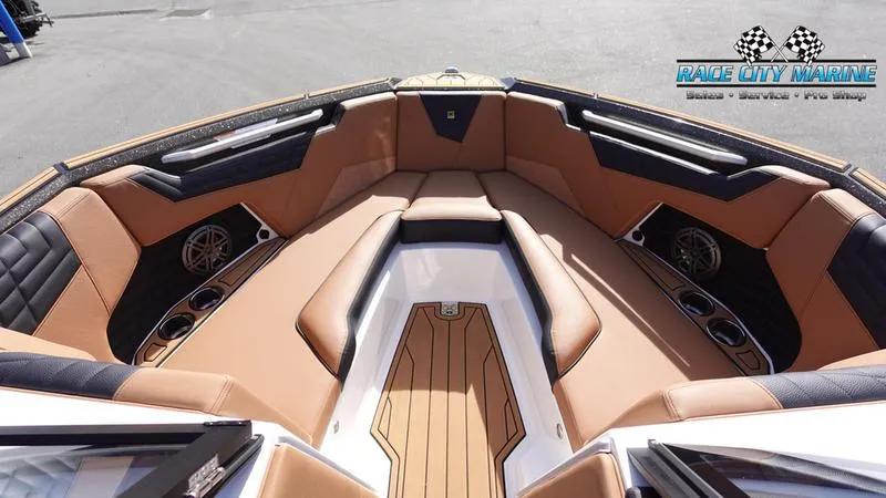 Slide: The Image of 2025 Nautique Super Air Nautique S23 boat interior with tan and black seating. - 42