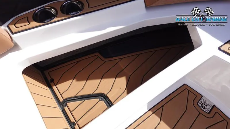 Slide: The Image of 2025 Nautique Super Air Nautique S23 interior with tan flooring and cup holders. - 45