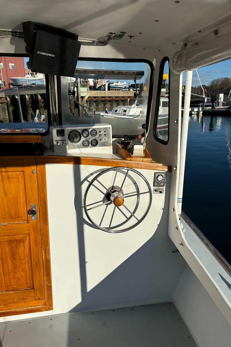 Slide: The Image of Interior of a 1992 Duffy 26' boat with wooden accents and steering wheel. - 11