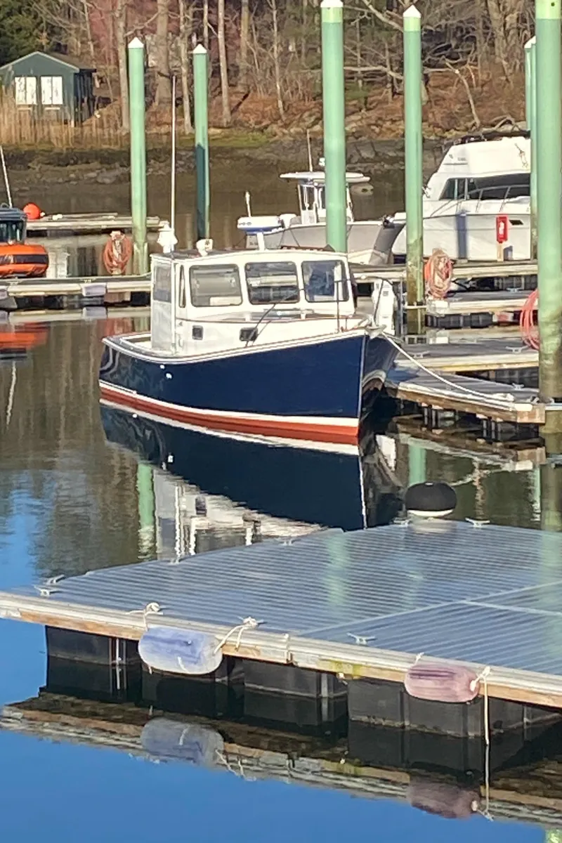 Slide: The Image of 1992 Duffy 26' boat docked in a marina, reflecting on calm water. - 2