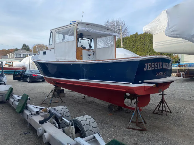Slide: The Image of 1992 Duffy 26' boat on stands, blue hull, named "Jessie Brene." - 7