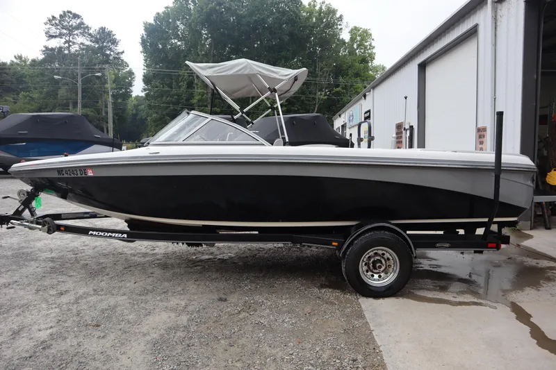 Slide: The Image of 2006 Moomba Outback LSV boat on trailer, parked outdoors near a building. - 3