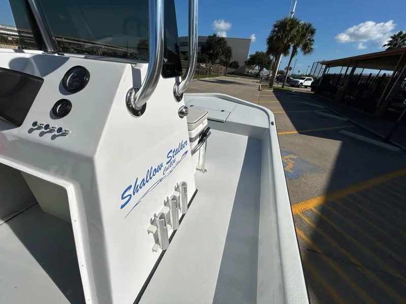 Slide: The Image of Shallow Stalker Cat 204 boat, 2025 model, parked outdoors under a clear blue sky. - 13