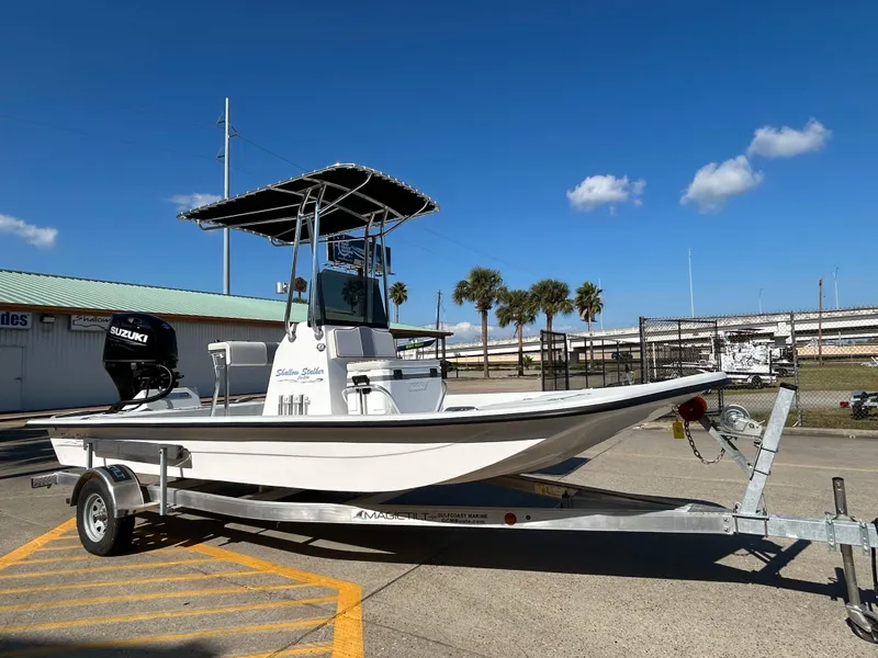 Slide: The Image of 2025 Shallow Stalker Cat 204 boat on trailer, parked outdoors under clear blue sky. - 2