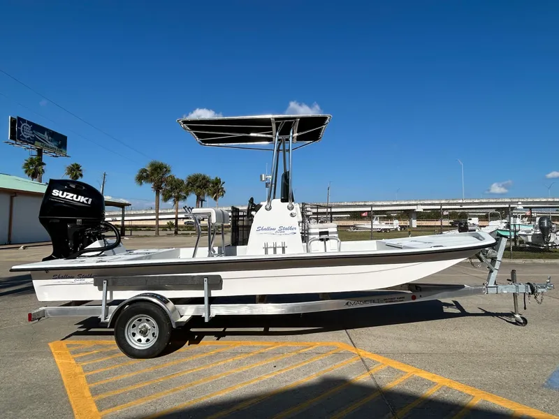 Slide: The Image of 2025 Shallow Stalker Cat 204 boat on trailer, sunny day, palm trees in background. - 4