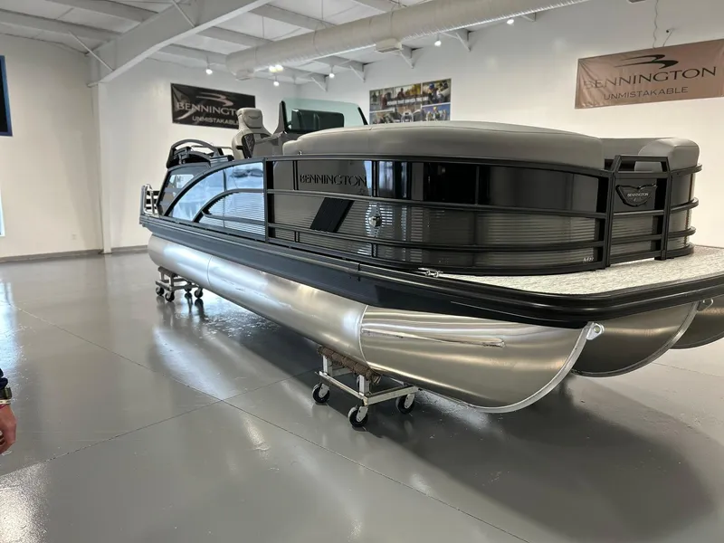 Slide: The Image of 2025 Bennington 22 MSB pontoon boat displayed in a showroom. - 0