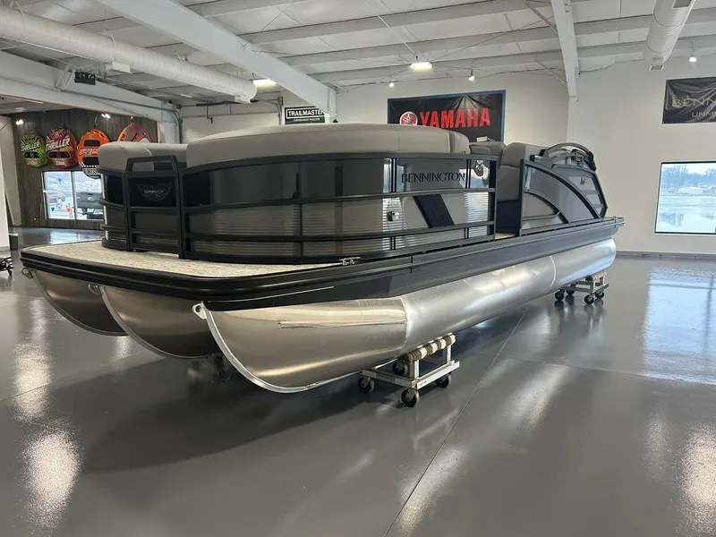 Slide: The Image of 2025 Bennington 22 MSB pontoon boat displayed in a showroom. - 1
