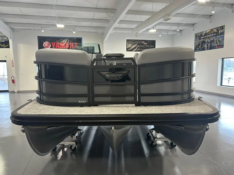 Slide: The Image of 2025 Bennington 22 MSB pontoon boat displayed in a showroom. - 2