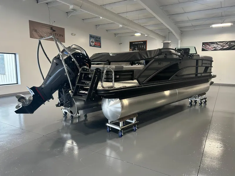 Slide: The Image of 2025 Bennington 22 MSB pontoon boat in showroom, featuring sleek design and powerful outboard motor. - 4