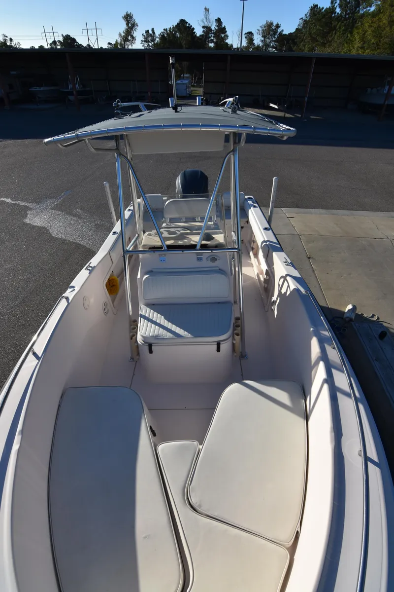 Slide: The Image of 2005 Grady-White Escape 209 boat with seating and canopy in a marina. - 18
