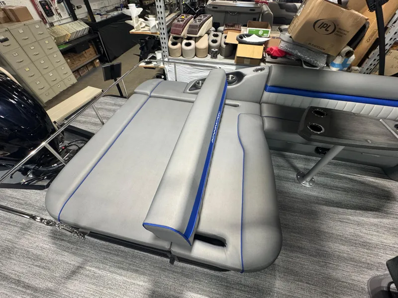 Slide: The Image of 2025 Bennington 24 LXSSB boat interior with gray and blue seating, cup holders, and storage. - 11