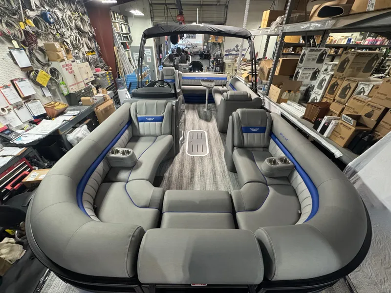 Slide: The Image of 2025 Bennington 24 LXSSB pontoon boat with luxurious seating in a showroom. - 2