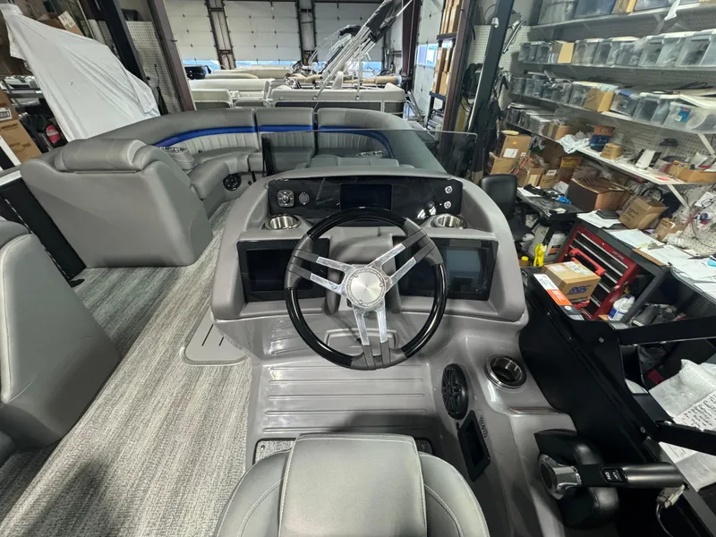 Slide: The Image of 2025 Bennington 24 LXSSB boat interior with modern steering console and seating. - 8