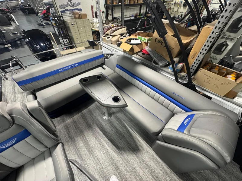 Slide: The Image of 2025 Bennington 24 LXSSB pontoon boat interior with gray and blue seating and table. - 9