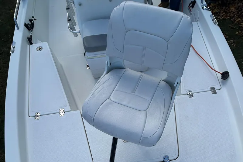 Slide: The Image of 2018 Mako 19 CPX boat interior with white cushioned seat. - 12