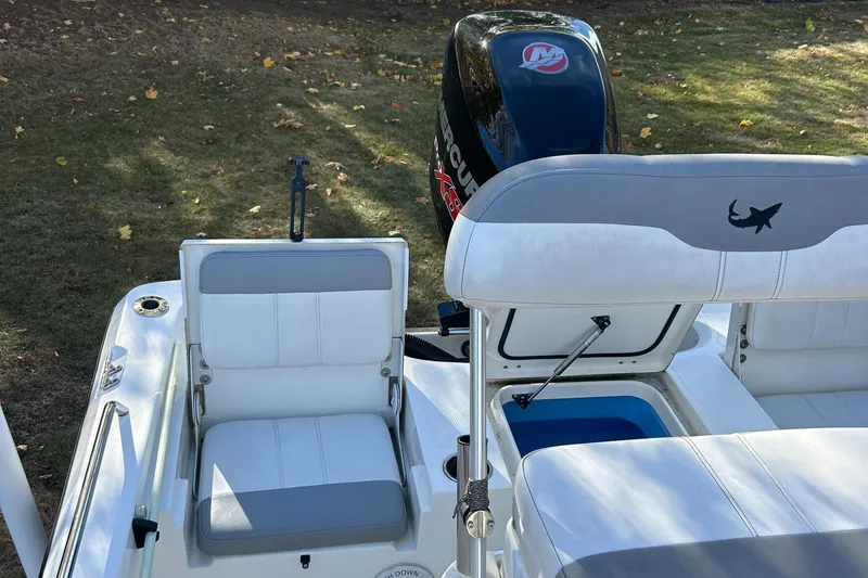 Slide: The Image of 2018 Mako 19 CPX boat interior with seating and motor, outdoors. - 14