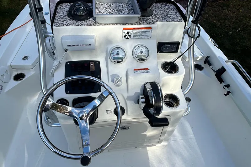 Slide: The Image of 2018 Mako 19 CPX boat console with steering wheel and gauges. - 16