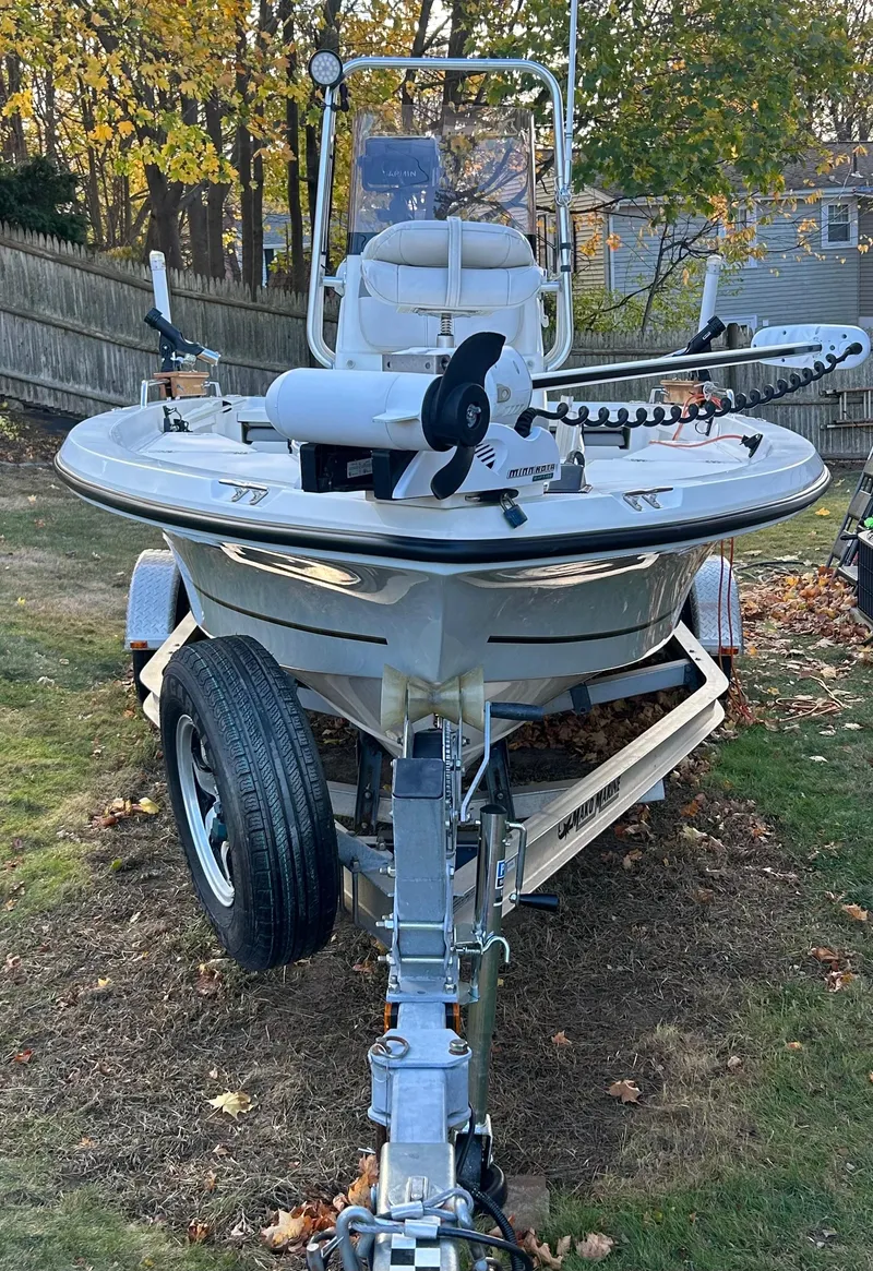 Slide: The Image of 2018 Mako 19 CPX boat on trailer in a yard with autumn leaves. - 2