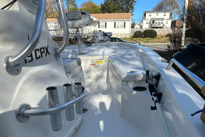 Slide: The Image of 2018 Mako 19 CPX boat interior with rod holders and seating. - 9