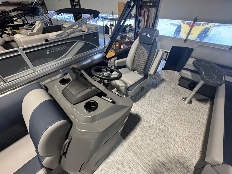 Slide: The Image of 2025 Bennington 20 SL boat interior with steering console and seating area. - 2